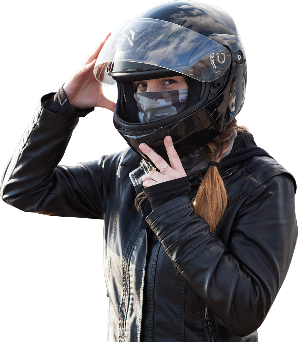 Young European girl biker trying black motorcycle helmet for ride on bike